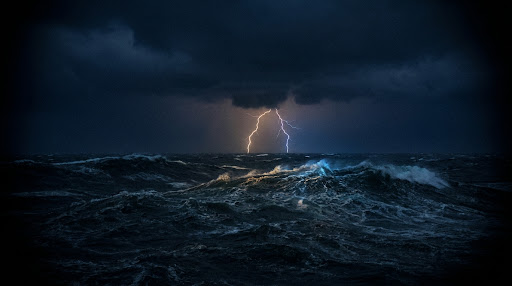 A dramatic storm over the dark ocean with powerful lightning striking the water.